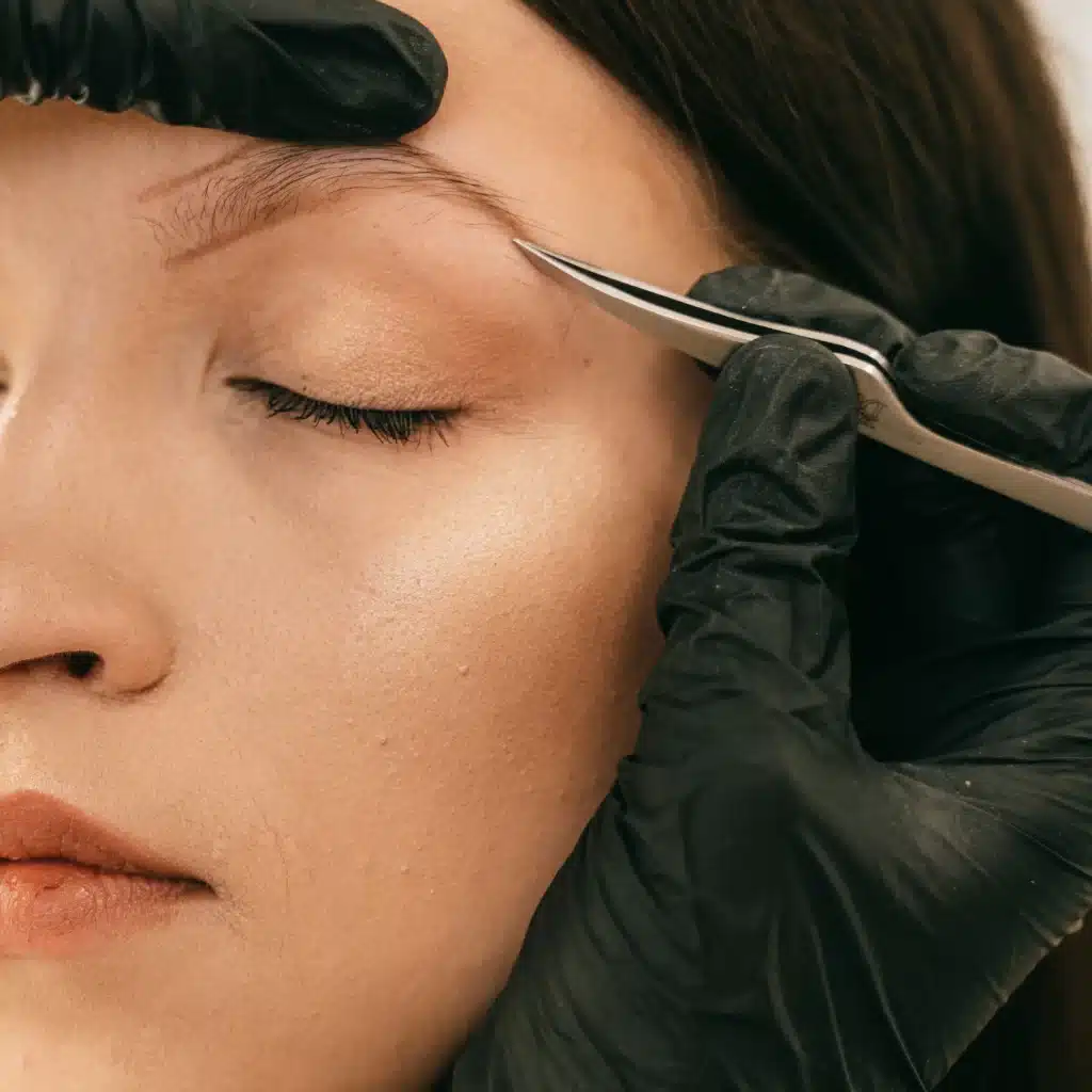 Esthéticienne qui épile les sourcils d'une femme